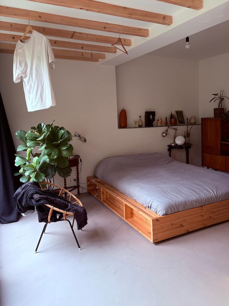 Minimalistisch interieur met een gietvloer en balken in het zicht. 